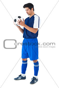Handsome football player in blue holding the ball