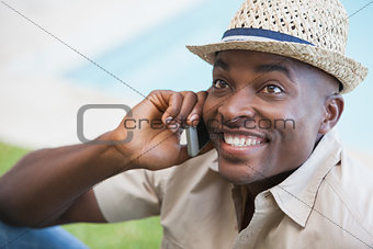 Happy man relaxing in his garden talking on phone