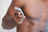 Shirtless man texting on phone