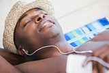 Shirtless man smiling and listening to music