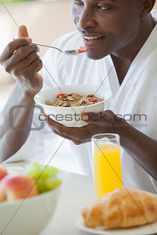 Happy man eating bowl of cereal outside