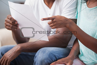 Couple sitting on their couch paying their bills