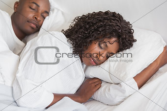 Happy couple sleeping together in bed