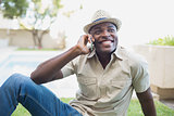 Smiling man relaxing in his garden talking on phone