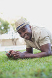 Smiling man relaxing in his garden texting on phone