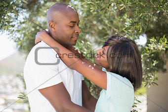 Happy couple hugging each other in garden