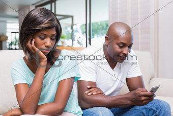 Unhappy woman watching her boyfriend texting