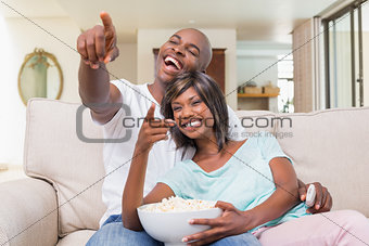 Happy couple relaxing on the couch watching tv