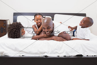 Happy family laughing together in bed