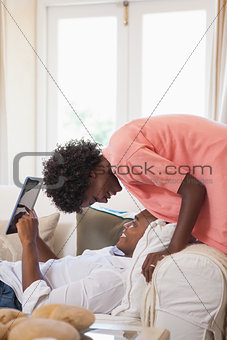 Happy couple relaxing on the couch with tablet pc