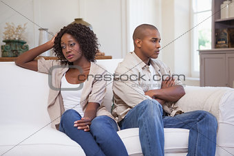 Unhappy couple not speaking to each other on sofa