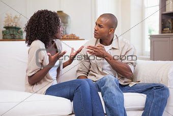 Unhappy couple arguing on the couch