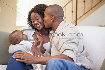Happy parents spending time with baby on the couch