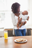Happy mother holding baby son at breakfast time