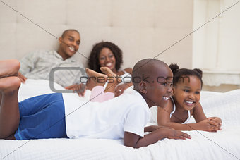 Happy family lying on bed smiling