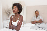 Unhappy couple not speaking to each other on bed