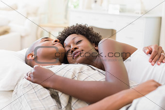 Happy couple lying in bed together