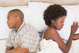Unhappy couple lying on bed not talking