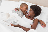 Happy couple lying in bed cuddling