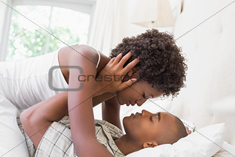 Intimate couple cuddling lying on their bed