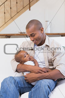 Happy father spending time with baby on the couch