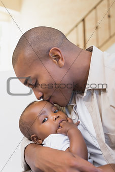 Happy father spending time with baby on the couch