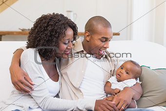 Happy parents spending time with baby on the couch