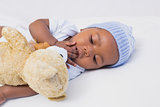 Adorable baby boy sleeping peacefully with teddy