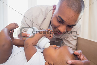 Happy father feeding his baby boy