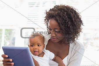 Happy mother using tablet pc with baby boy
