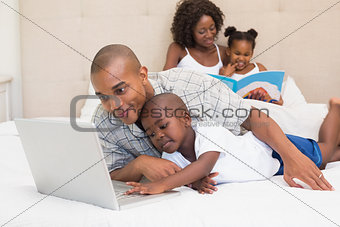 Happy family spending time together on bed