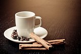 white cup with coffee near coffee beans over wood table