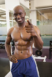 Smiling shirtless muscular man in gym
