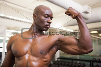 Muscular man flexing muscles in gym