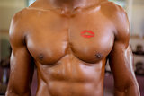 Shirtless muscular man with lipstick mark on chest