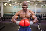 Muscular boxer flexing muscles in health club