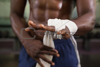Muscular man binds bandage on his hand