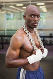 Serious shirtless muscular man in gym