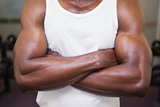 Mid section of a muscular man with arms crossed