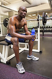 Muscular man with energy drink in gym