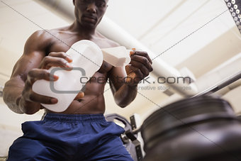 Body builder scooping up protein powder