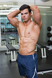 Shirtless muscular man posing in gym