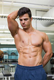 Serious shirtless muscular man in gym