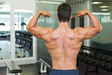 Rear view of a muscular man flexing muscles