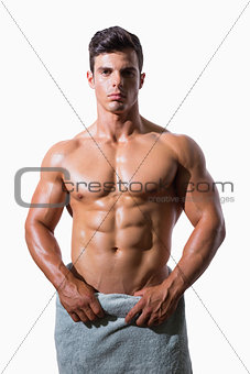 Portrait of a shirtless muscular man wrapped in white towel
