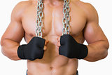 Mid section of a shirtless muscular man holding chain