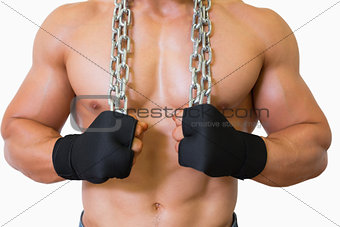 Mid section of a shirtless muscular man holding chain