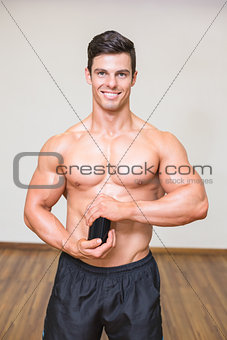 Body builder holding bottle with supplements in gym