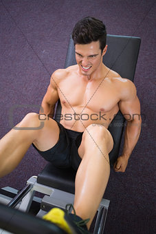 Male weightlifter doing leg presses in gym