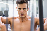 Determined shirtless young muscular man in gym